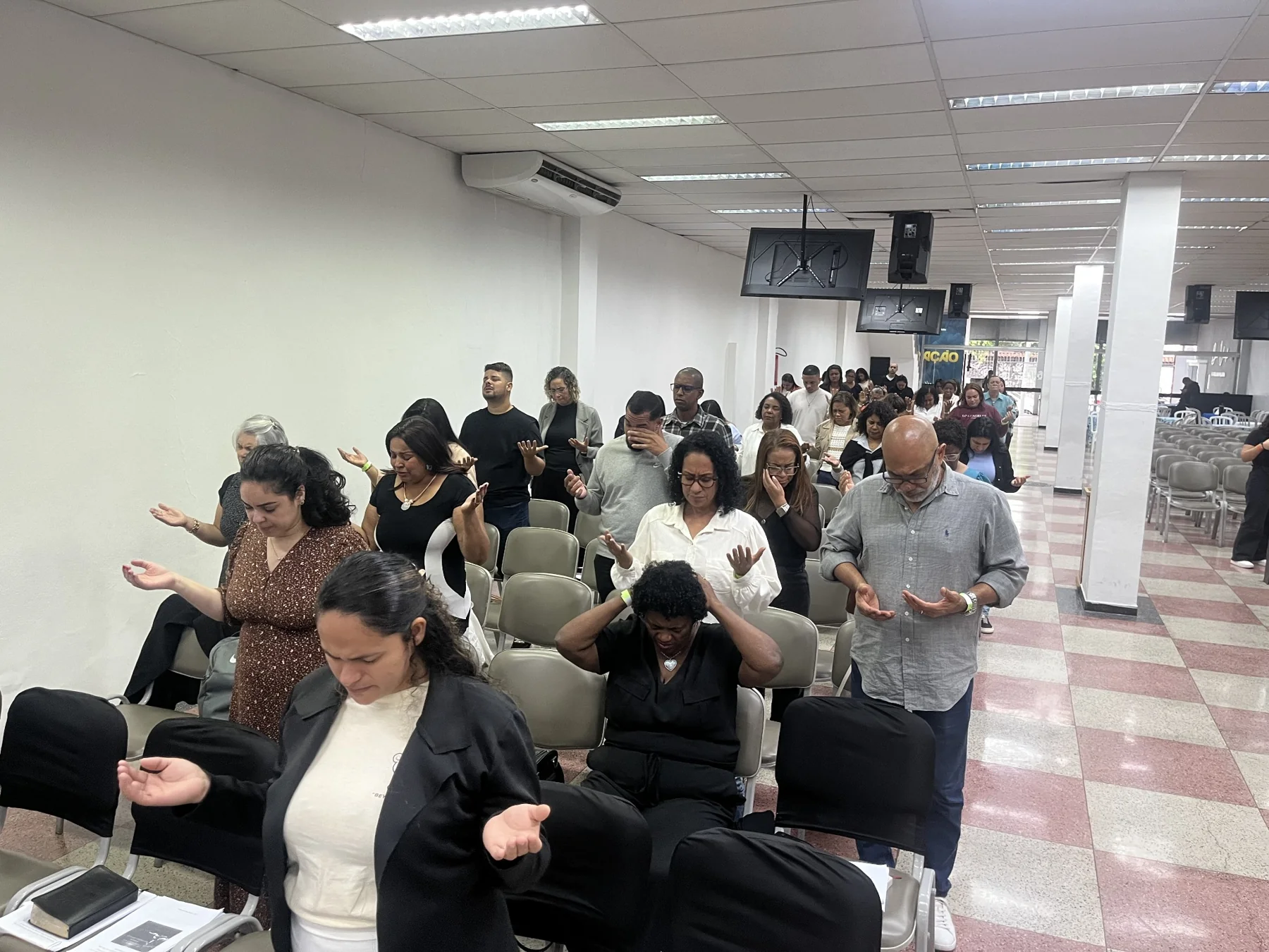 Participantes em um momento de oração coletiva